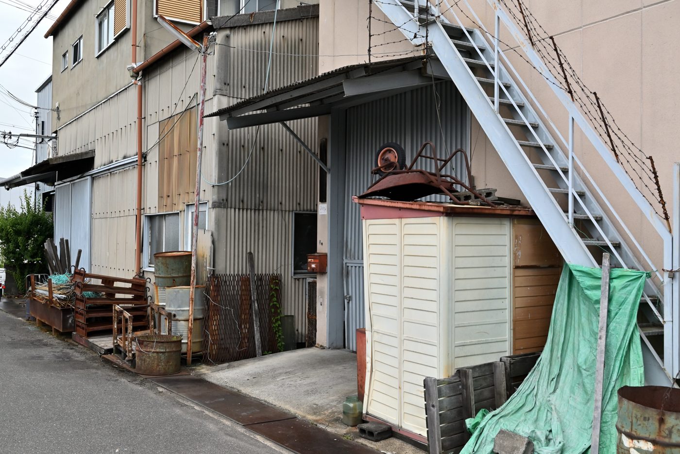 外階段と物置がある古い建物の裏手