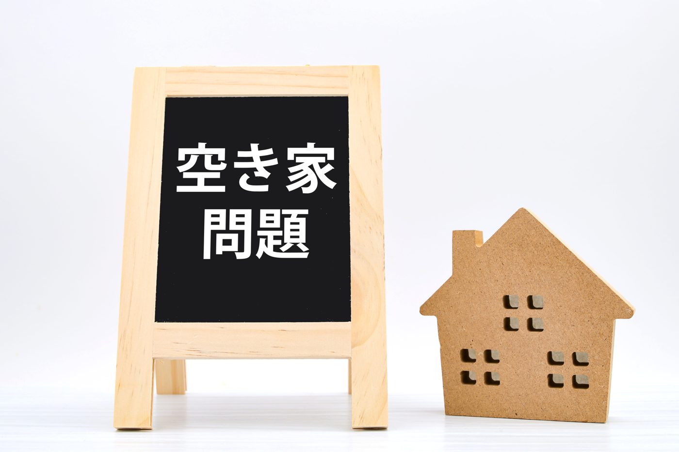 「空き家問題」と書かれた黒板と家の模型