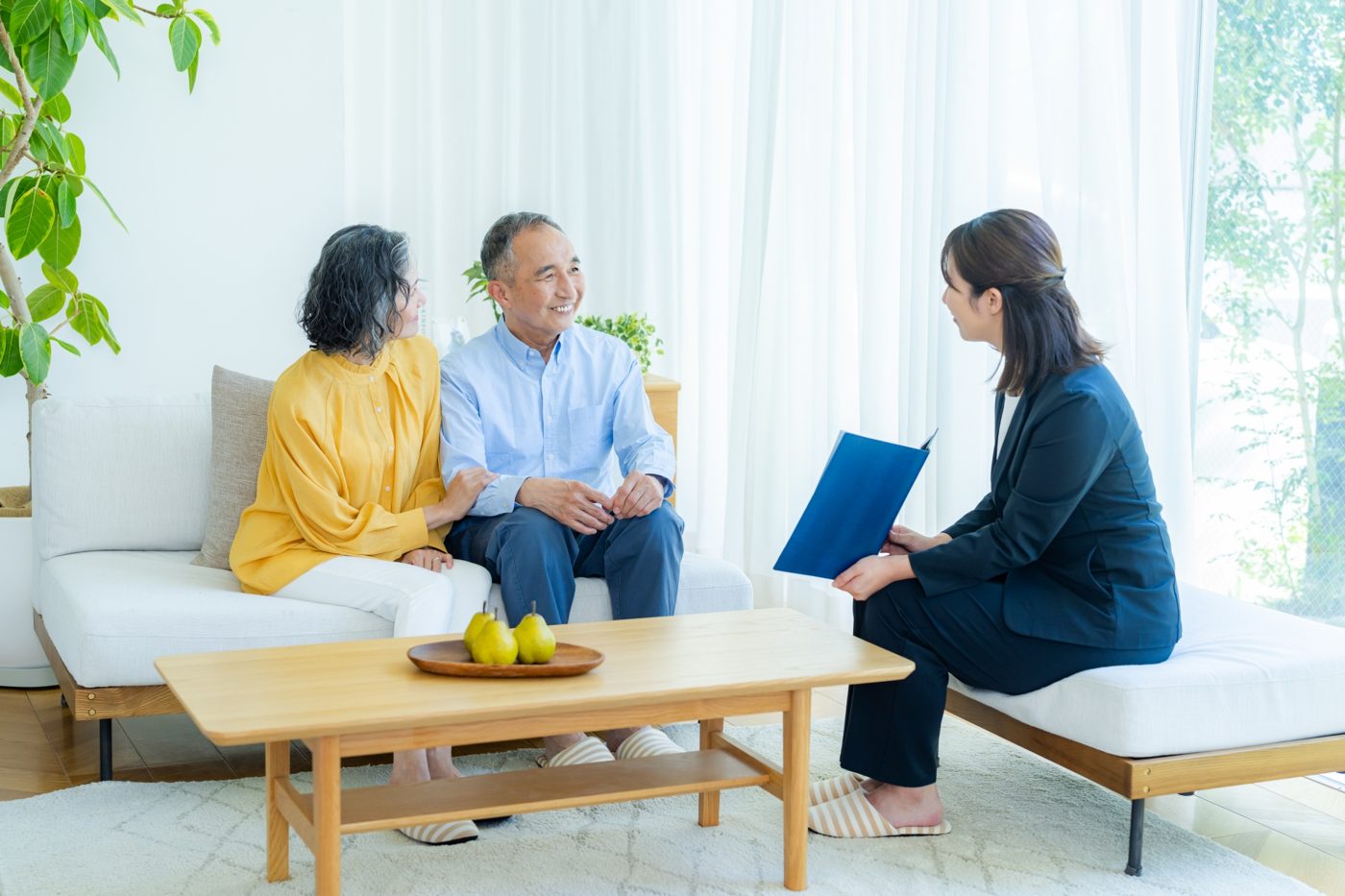 ご自宅のリビングでご夫婦の相談を受ける担当者
