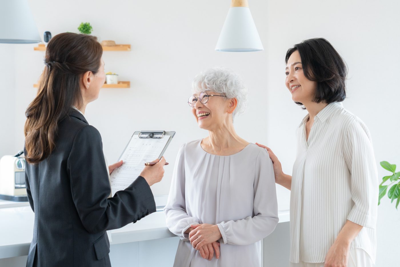 クリップボードを手に家族と話す担当者