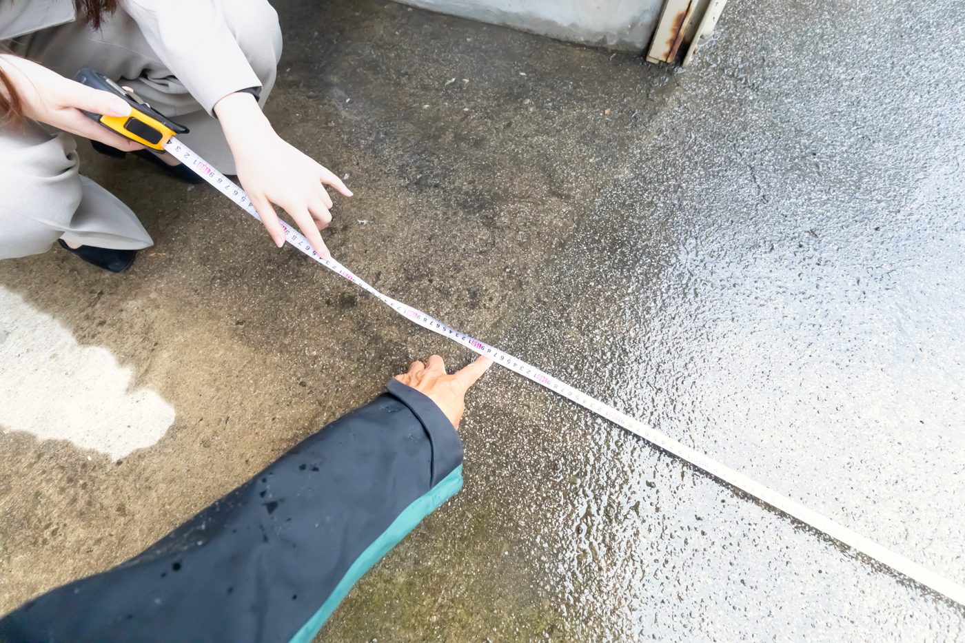 メジャーで敷地の寸法を測る現地調査
