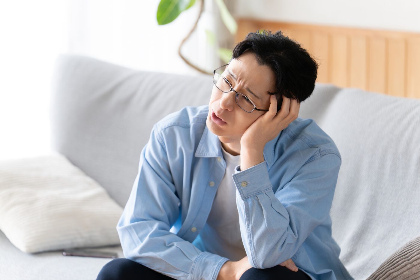 ソファで考え込む男性